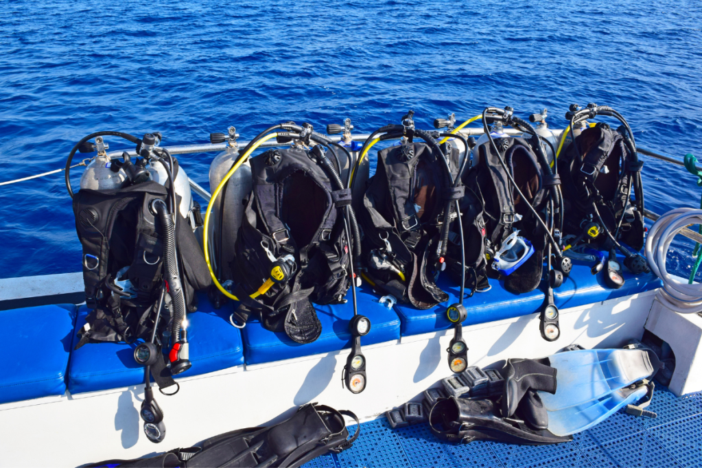 A row of scuba gear on a dive boat
