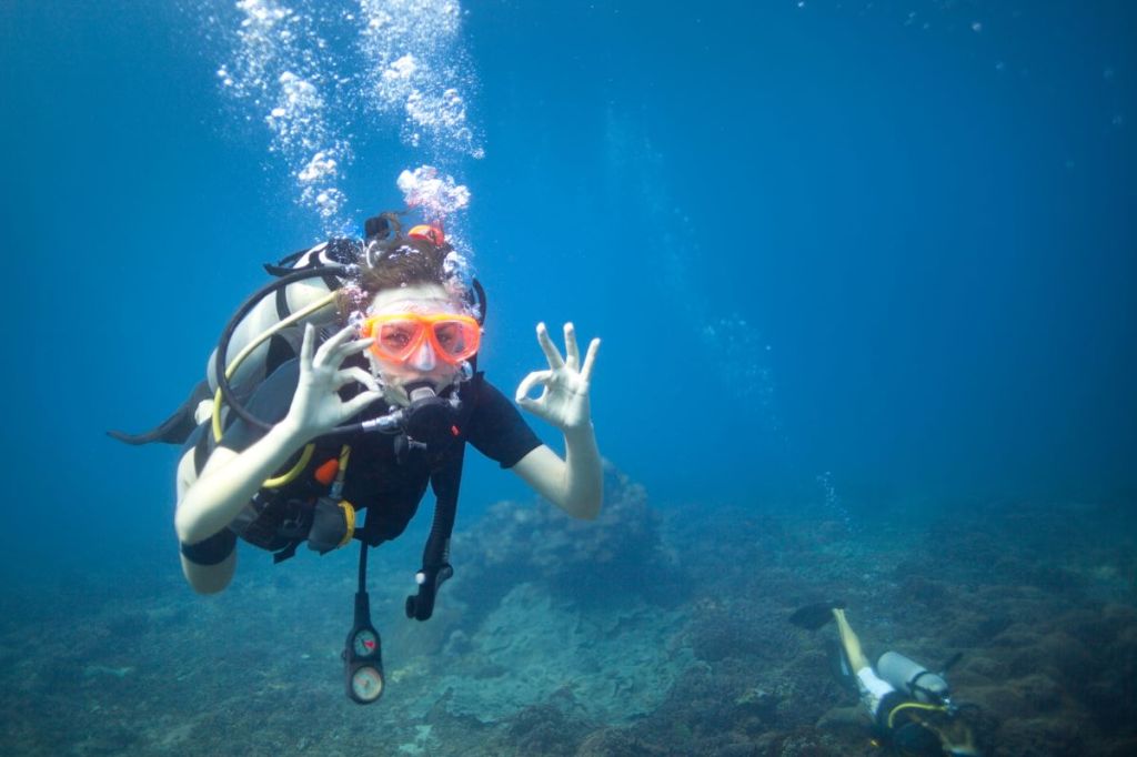 A scuba woman signally ok underwater